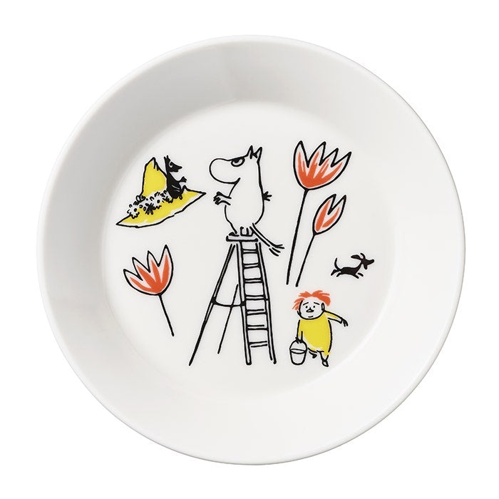 Kuvassa Muumi -lautanen, missä on Tove Janssonin Punaiselle Ristille piirtämä Muumipeikko-hahmo kiipeilee tikapuilla.