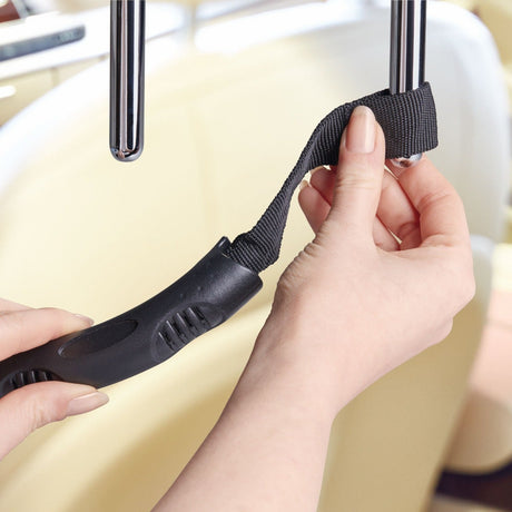 Kuvassa näytetään kuinka apukahva kiinnitetään auton etupenkin niskatukeen
