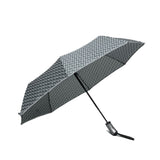 Sateenvarjossa graafine musta-harmaa-valkoinen kuviointi sekä reunassa heijastintere.