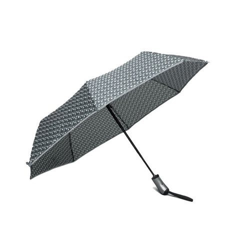 Sateenvarjossa graafine musta-harmaa-valkoinen kuviointi sekä reunassa heijastintere.